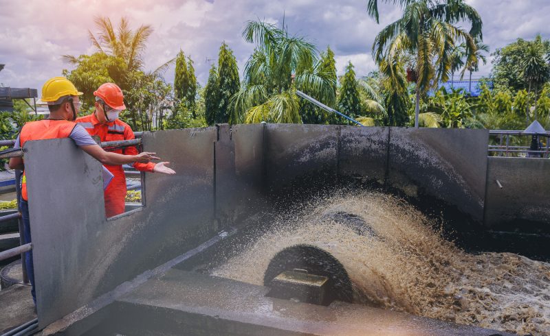 Two technicians are maintenance with water turbine at wastewater treatment system.