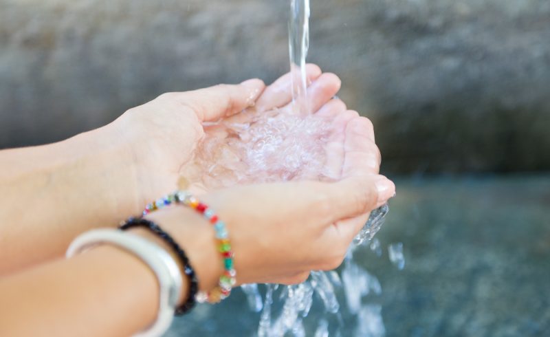 Portrait of woman's hands with water splash.